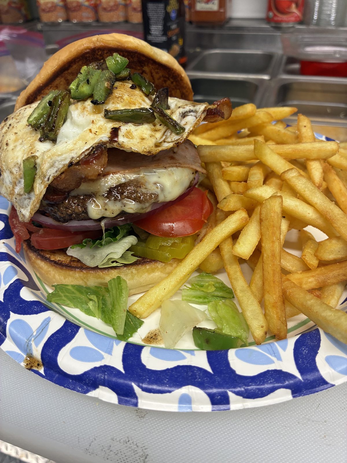 Burger topped with fried egg and fries
